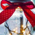 Christmas mason jar luminary with red ribbon tied on top